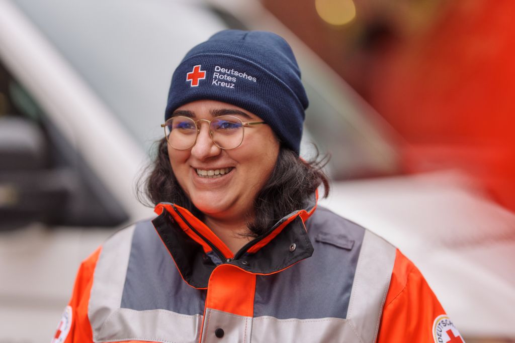 Symbolfoto DRK - Helferin mit blauer Mütze mit DRK - Logo