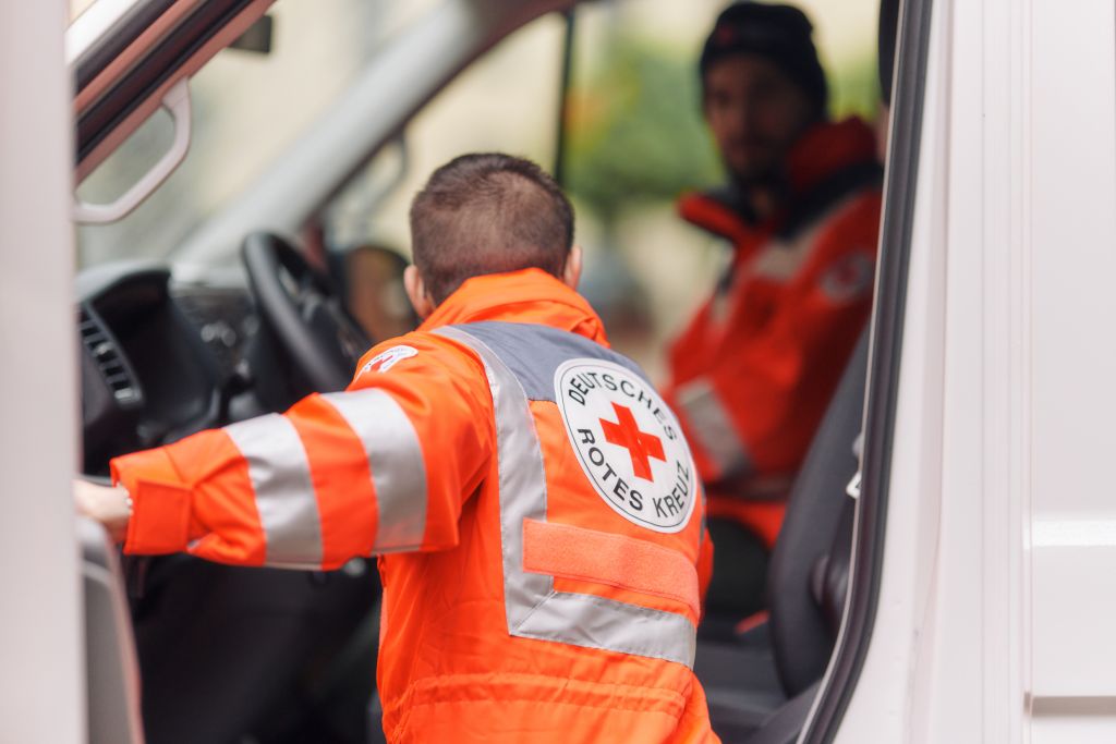 Symbolfoto DRK - Helfer am Einsatzfahrzeug